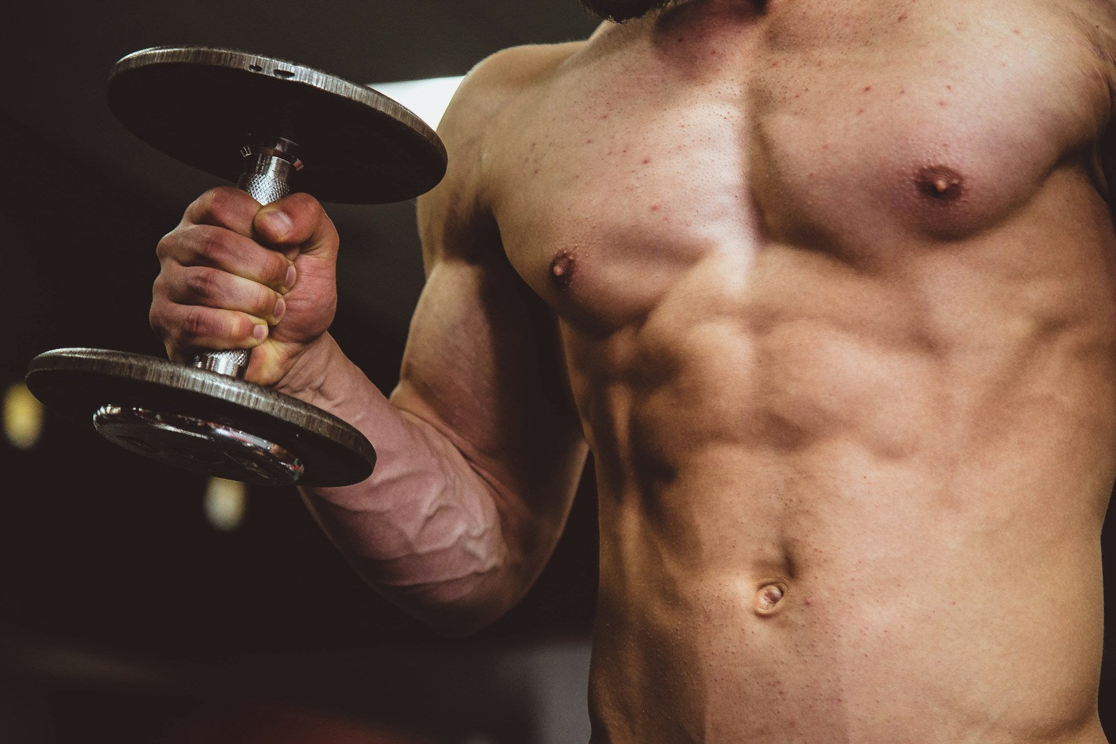 Pratiquant de musculation tenant un haltère, bras congestionné