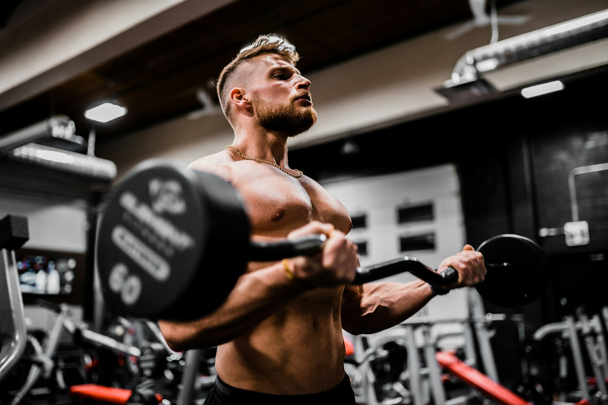 Pratiquant exécutant un curl avec haltère en salle de musculation, bras en contraction