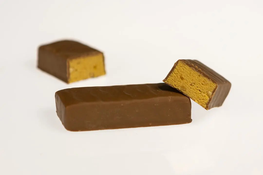 Barre protéinée au chocolat coupée en deux, souvent sucrée au maltitol